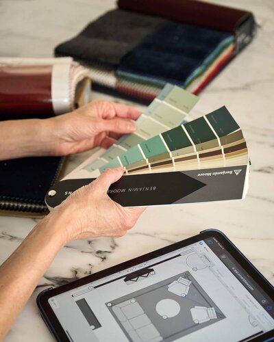 A woman holding a paint swatch booklet