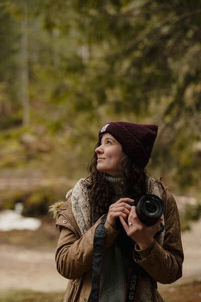 Girl in the dolomites holding a camera