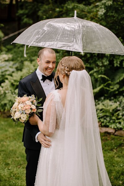 Bride and groom first look under clear umbrella