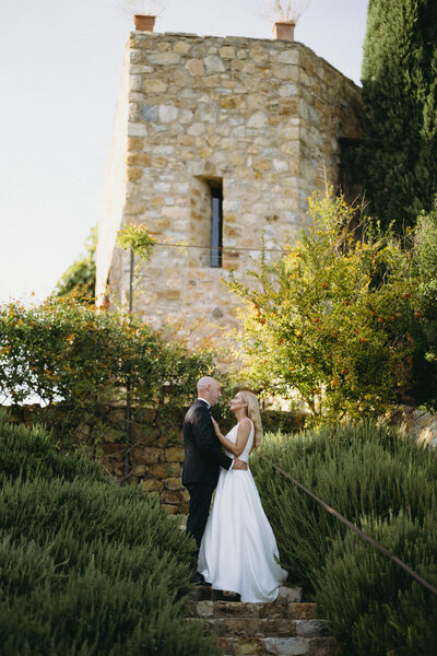 Couple sharing a private moment alone of their wedding day in a beautiful green setting outside.