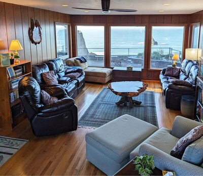 Living room with wood walls and floor viewing the ocean