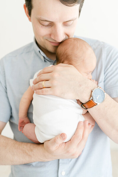 Louisville KY dad holds sleeping newborn baby during newborn pictures at Julie Brock Photography
