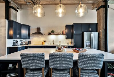 Bar seating at kitchen island  in this 3-bedroom, 2-bathroom luxury condo in downtown Waco, TX