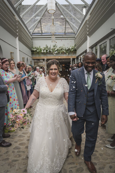 Melissa & Dexter walking through a Confetti tunnel