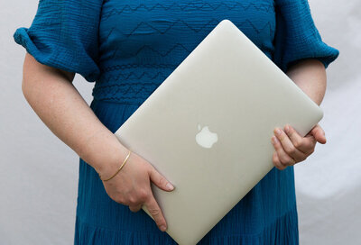 Graphic, web and branding designer Bess Brownlee hold her laptop in Missoula, Montana.