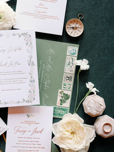Flat lay of pink and green wedding invitation suite.