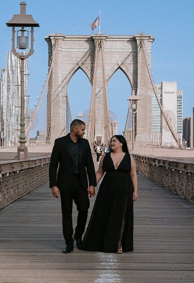 Elegantly dressed Latino couple holding hand in hand strolling through the Brooklyn Bridge Park.