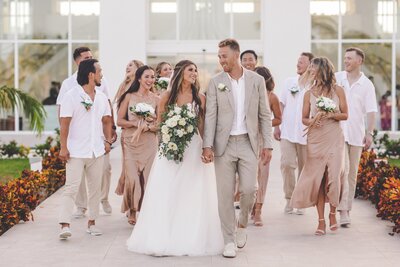 Groom hugging bride on beach after wedding in Riviera Maya
