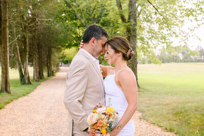 Bride and Groom Rest their heads against one another in outdoor wedding photo in Northern VA