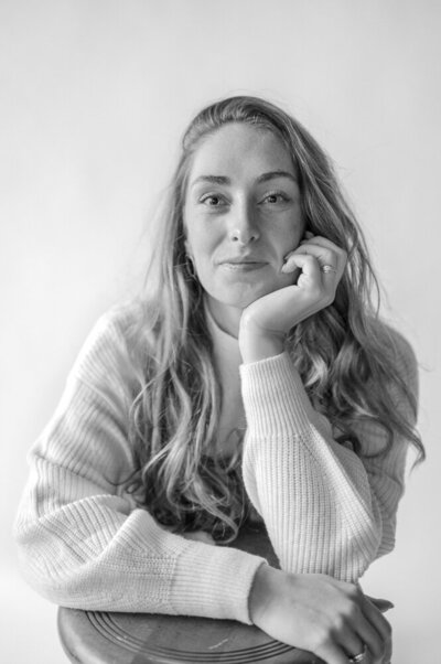 headshot of Jackie sitting with her hand resting on her chin