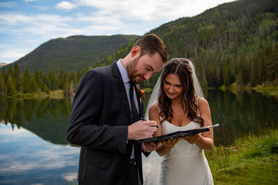 Bride and Groom laugh at a joke the groom made at the overlook to an alpine lake.