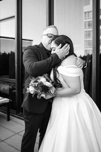 Bride being embraced by father during the father bride first look.