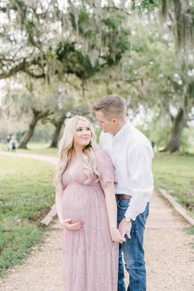 Father-to-be embraces his pregnant wife during maternity portrait