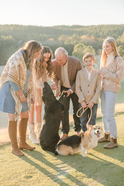 Family of five smiling down at their two dogs. -Family Photographer Greenville SC