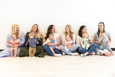 Group of women sitting on the floor holding their babies