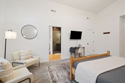 Cozy bedroom with chairs, desk, and modern decor
