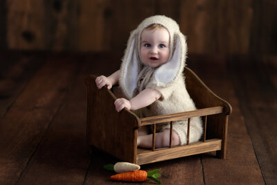 With his cozy bunny bonnet and vintage setting, this baby girl’s milestone session is a sweet nod to imagination and rustic styling.