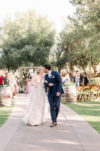 Bride and groom kissing  down the aisle at Long Shadow Ranch Winery