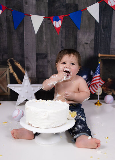 One-year-old smiling during themed cake smash session in Waldwick, NJ