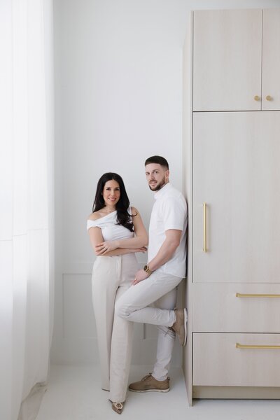 Caroline and Steven leaning against cupboard and smiling