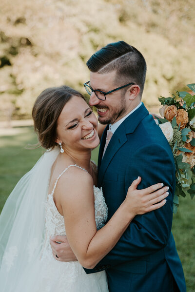 bride and groom laughing on their wedding day in the summer