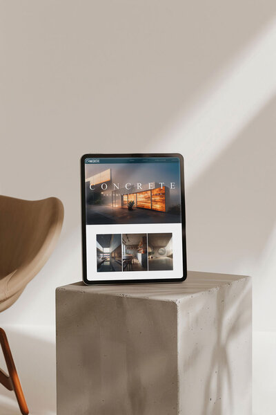 Tablet displaying the Concrete Architectural Design website resting on a slab of concrete, blending modern web design with industrial elements.