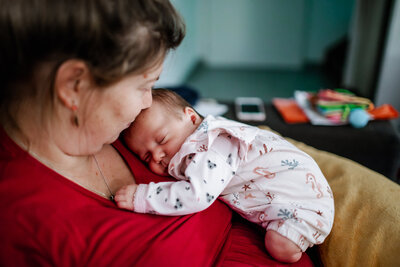 A newborn girl sleeping on her mom's chest