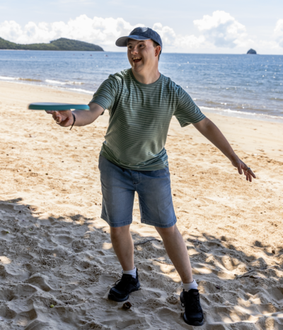 Young man playing frisbee at Palm Cove beach