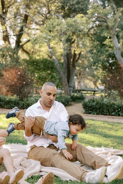 dad playing airplane with son