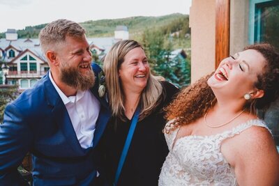 A colorado wedding planner laughing with her clients