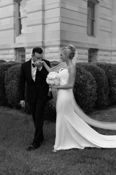 Bride and Groom walking in front of Greencrest Manor in a Black tux and a Berta Wedding gown by wedding photographers chicago Allison Francois Photography