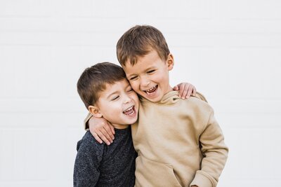 Two boys hugging each other, captured beautifully by a Pittsburgh family photographer.