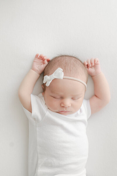 sleeping baby girl with hands above her head