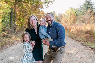 a family of five sitting on a park at coker arboretum and having their photo taken by rosa ashdown