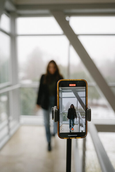 Social media manager walking towards camera recording on tripod