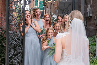 Bride smiles over her shoulder with her veil blowing behind her