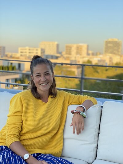 Portrait von Moderatorin Hanna Zöller im gelben Pullover, entspannt auf Couch in München, persönliche Vorstellung