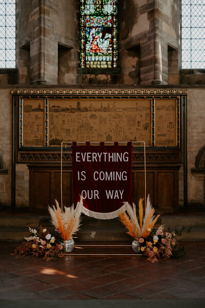 A custom banner on a metal frame with disco balls full of pampas grass at a wedding at Left Bank in Leeds. 
