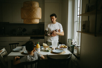 En mamma tittar på sin dotters hand under en familjefotografering i Göteborg