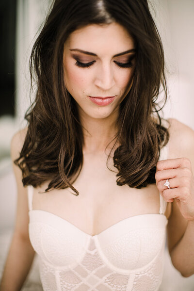 Bride wears soft white lingerie for her bridal boudoir session.