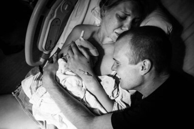 Mother and father embracing their newborn baby after birth at Michael Garron Hospital in Toronto.