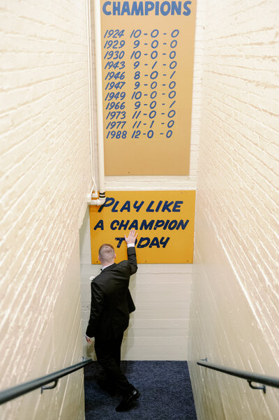 a groom looking at a sign in a sports locker room