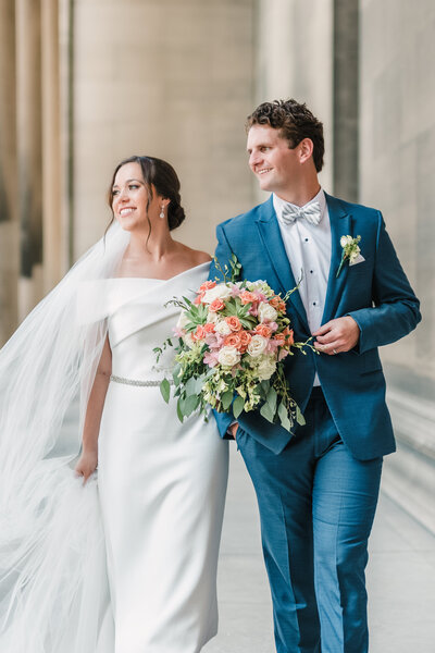 Bride and groom holding colorful bouquet outside a Pittsburgh wedding venue

