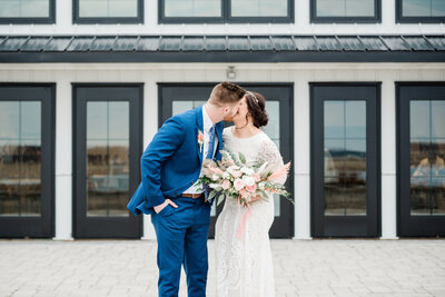 Bride and groom kissing in front of Crimson Lane wedding venue in Ada, Ohio