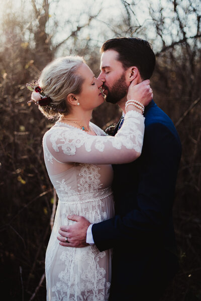 A bride and groom with their eyes closed about to kiss