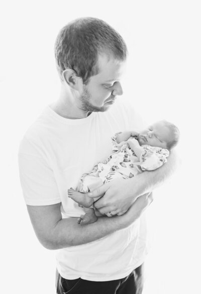 Photo of Dad holding newborn baby | Maine Newborn Photographer