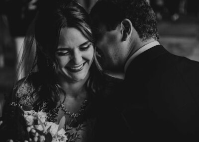 Bride and groom posing for portrait with white walls