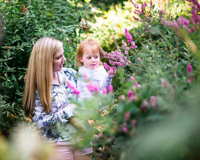 mom and daughter explore purple flowers