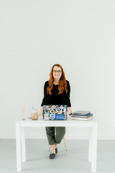 Heather of Heather Frable Photography standing behind a white desk