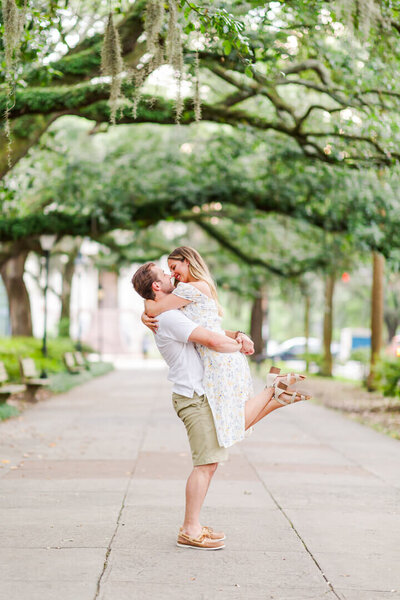 Couple hugging for an engagement session in a city park for Photography by Karla.